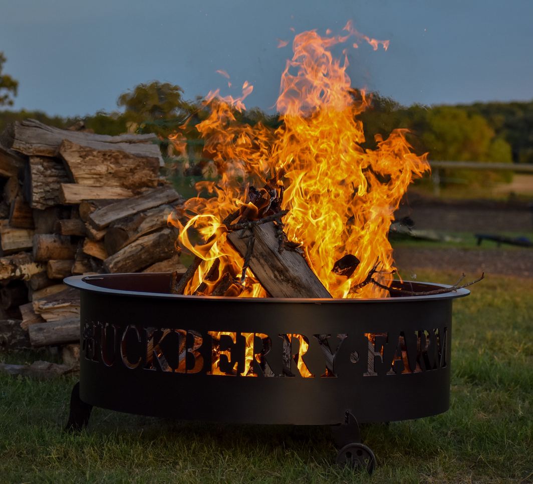 A wood fire roaring in the Huckberry Farm fire pit at dusk